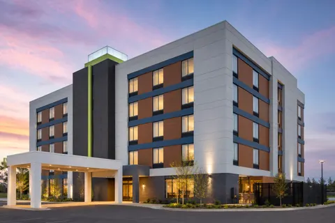 Light select-service hotel facade with warm exterior lighting