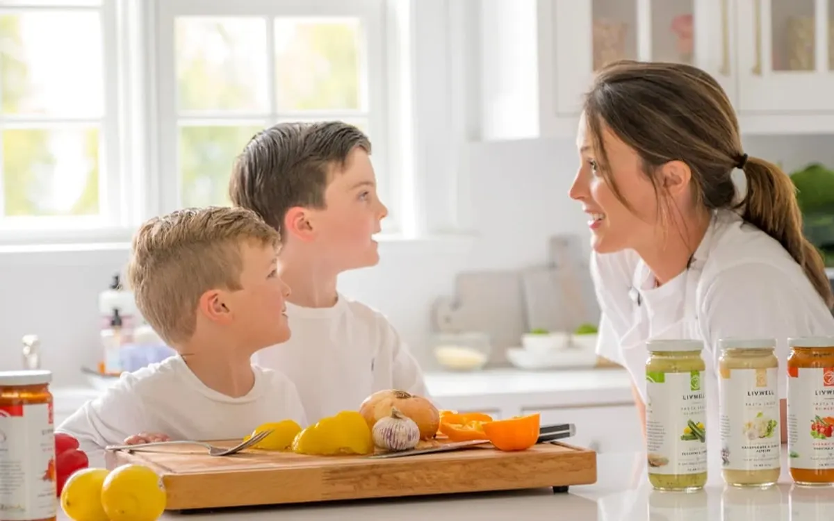 Olivia Napoli of LIVWELL with family and Livwell pasta sauces in a kitchen