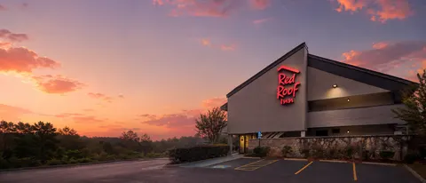 Red Roof Inn exterior at sunset with illuminated brand logo