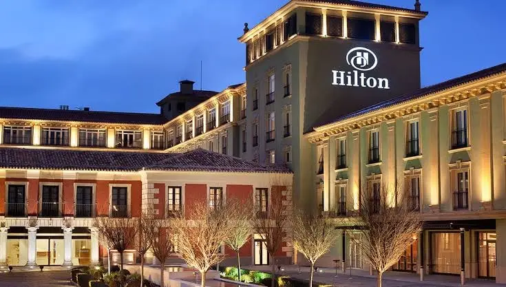 Tapestry Collection hotel exterior at dusk with courtyard trees